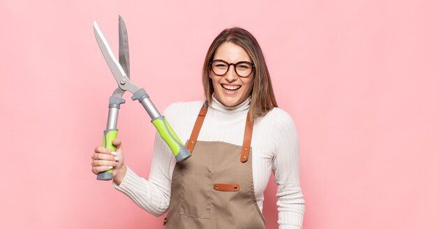 Young blonde woman looking happy and pleasantly surprised, excited with a fascinated and shocked expression