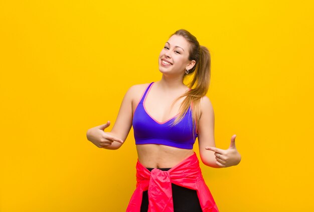 Young blonde woman looking proud, arrogant, happy, surprised and satisfied, pointing to self, feeling like a winner. sport concept