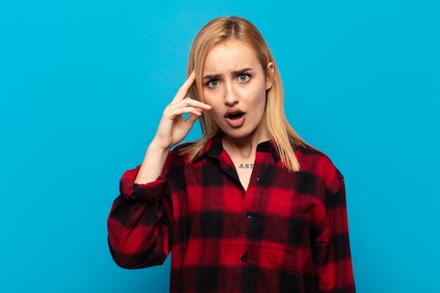 Young blonde woman looking surprised