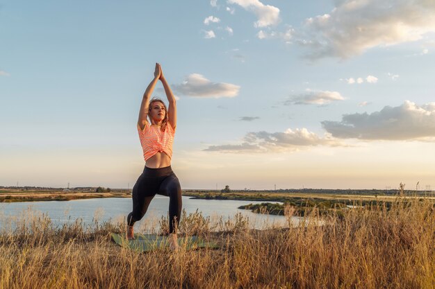 Young blonde woman making yoga outdoor