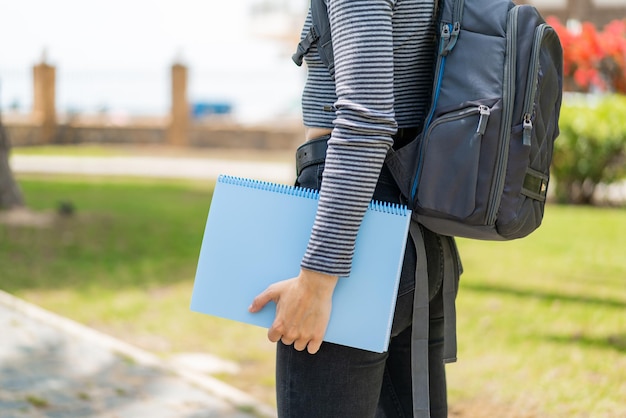 Photo young blonde woman at outdoors holding a notebook