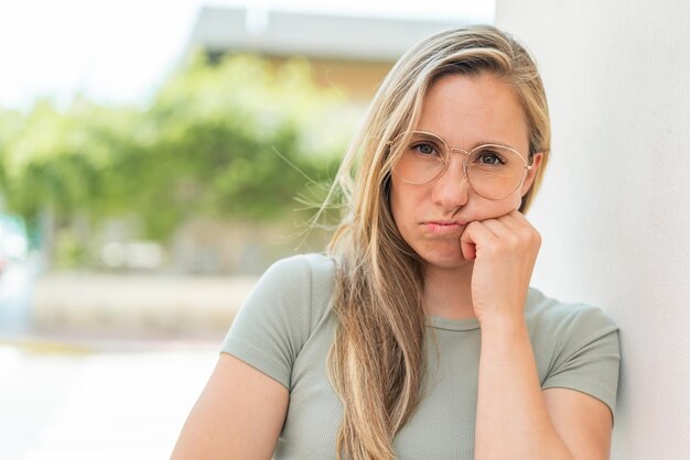 眼鏡と悲しい表情の若い金の女性