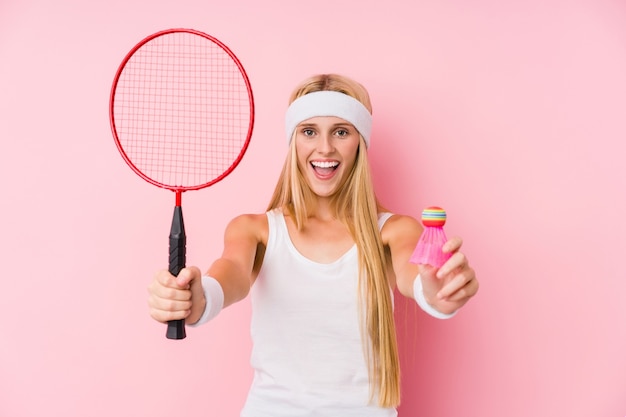 Young blonde woman playing badminton