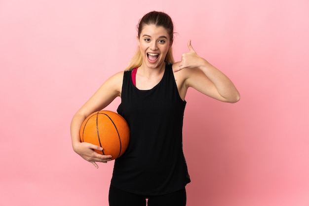 Young blonde woman playing basketball posing isolated against the blank wall