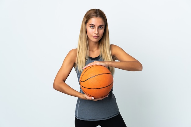 Young blonde woman over playing basketball