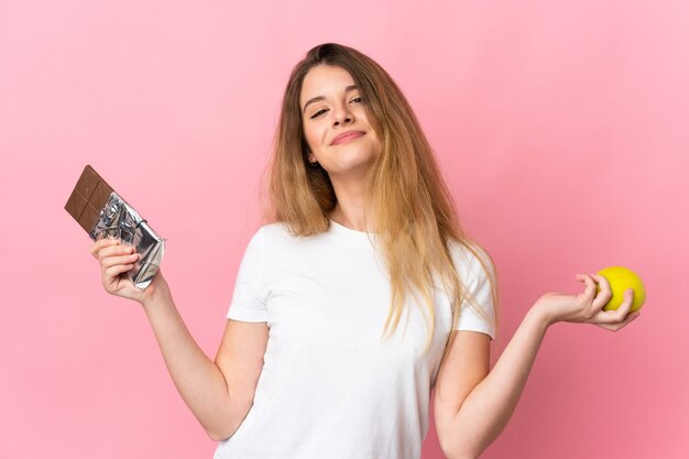 Young blonde woman posing isolated against the blank wall