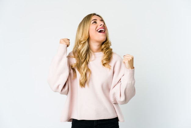 Young blonde woman raising fist after a victory