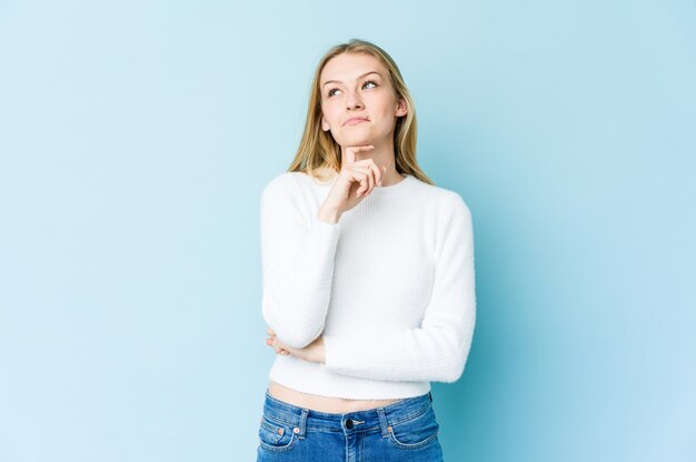 Young blonde woman relaxed thinking about something looking at a copy space.