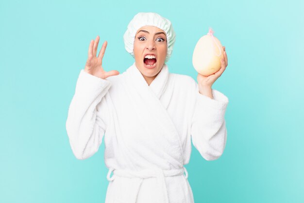 Young blonde woman screaming with hands up in the air. shower concept.