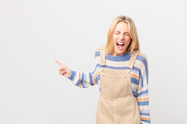 young blonde woman shouting aggressively, looking very angry