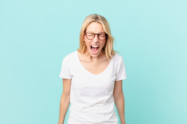 Young blonde woman shouting aggressively, looking very angry