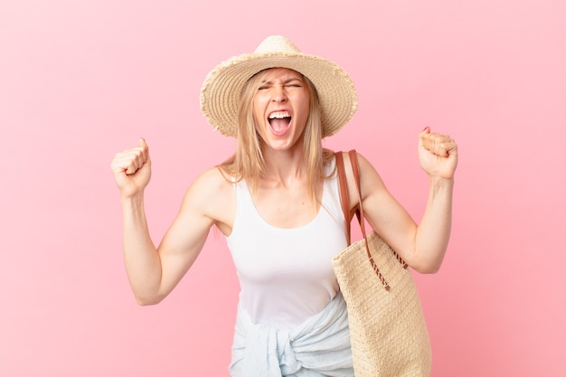 Young blonde woman shouting aggressively with an angry expression