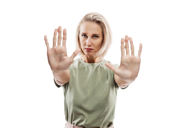 Young blonde woman shows hands with palms forward. Stop, no, protest.. Fight for your rights.