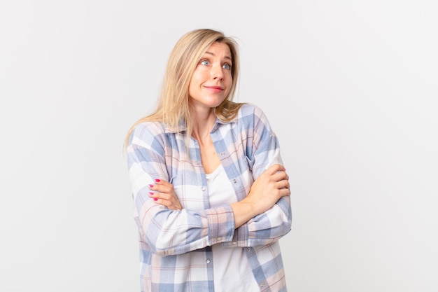 Young blonde woman shrugging feeling confused and uncertain