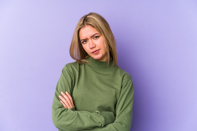 Young blonde woman suspicious, uncertain, examining you