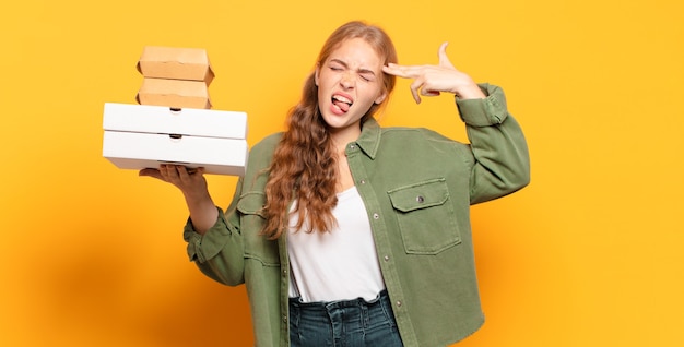 Giovane donna bionda che porta via gli alimenti a rapida preparazione