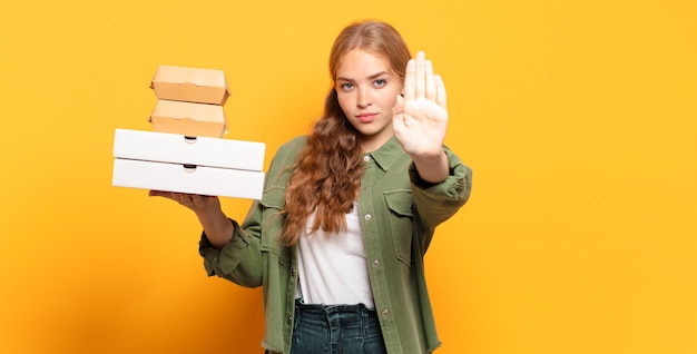 Young blonde woman taking fast food away