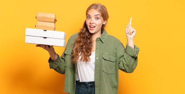 Giovane donna bionda che porta via gli alimenti a rapida preparazione