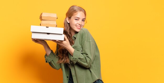 Giovane donna bionda che porta via gli alimenti a rapida preparazione