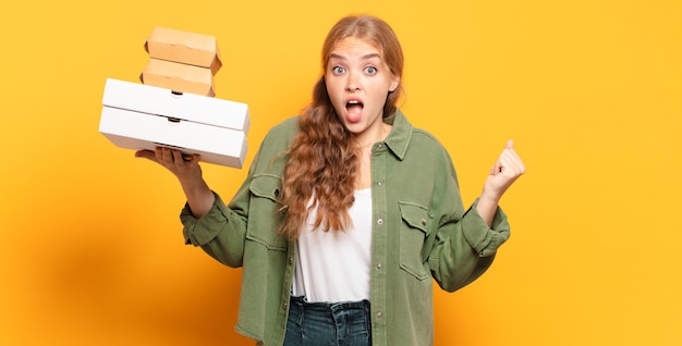 Young blonde woman taking fast food away