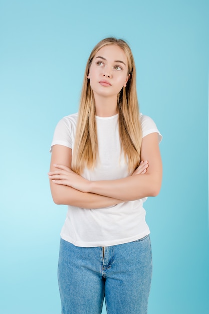 Young blonde woman thinking isolated over blue