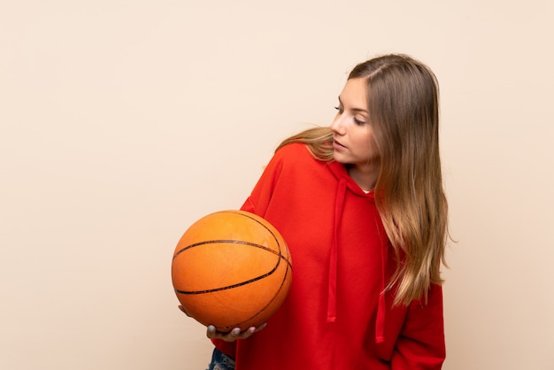 Young blonde woman with ball of basketball