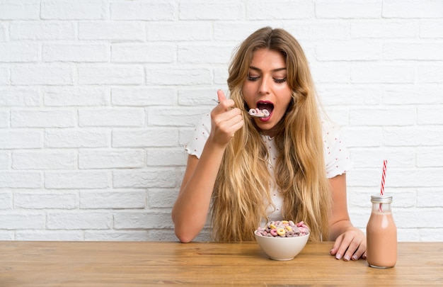 Young blonde woman with bowl of cereals