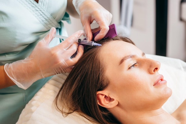 Young blonde woman with hair loss problem receiving injection, close up