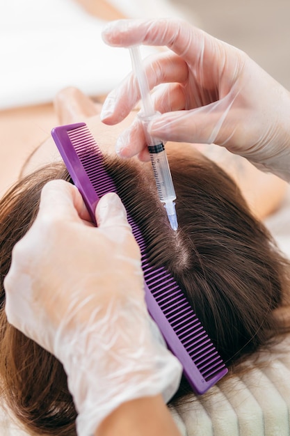 Foto giovane donna bionda con problemi di caduta dei capelli che riceve l'iniezione, primo piano