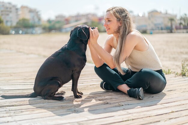 Photo young blonde woman with her dog at outdoors