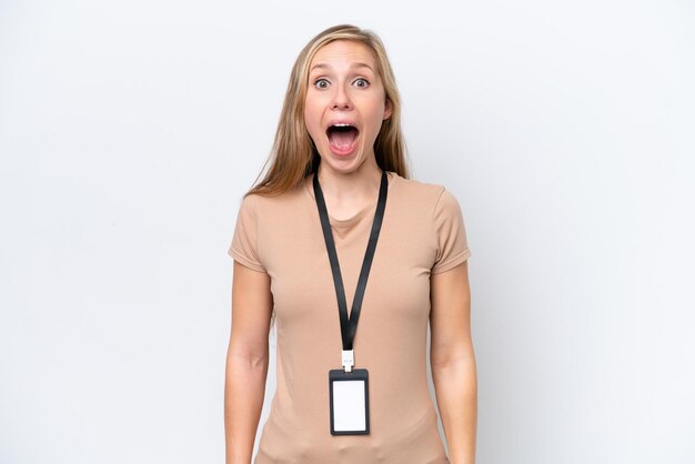 Young blonde woman with ID card isolated on white background with surprise and shocked facial expression