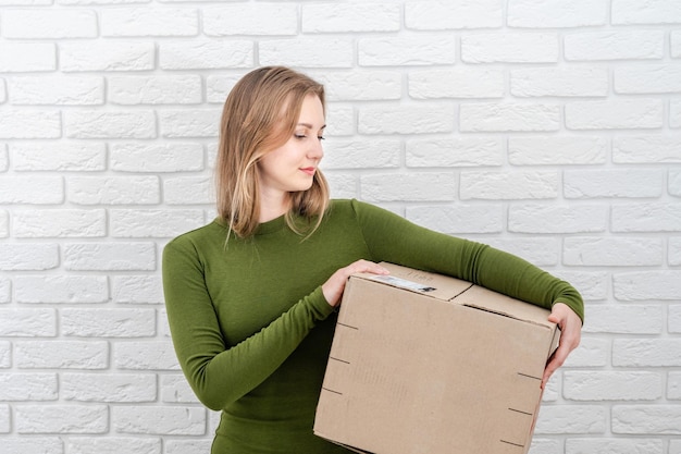 Young blonde woman with parcel box Delivering a parcel