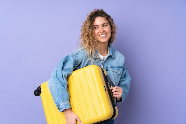 Young blonde woman with travel suitcase