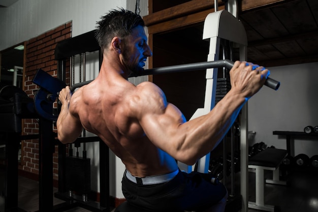 Photo young bodybuilder doing heavy weight exercise for back