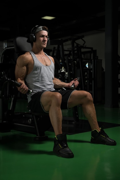 Young Bodybuilder Doing Heavy Weight Exercise For Biceps On Machine