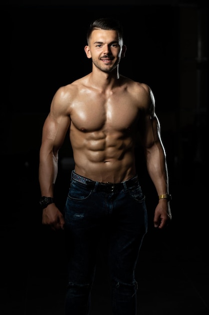 Young Bodybuilder In Jeans Flexing Muscles