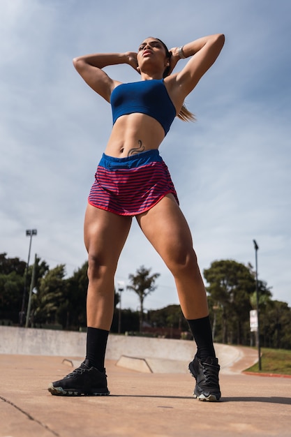 A young bodybuilder posing in the open air.