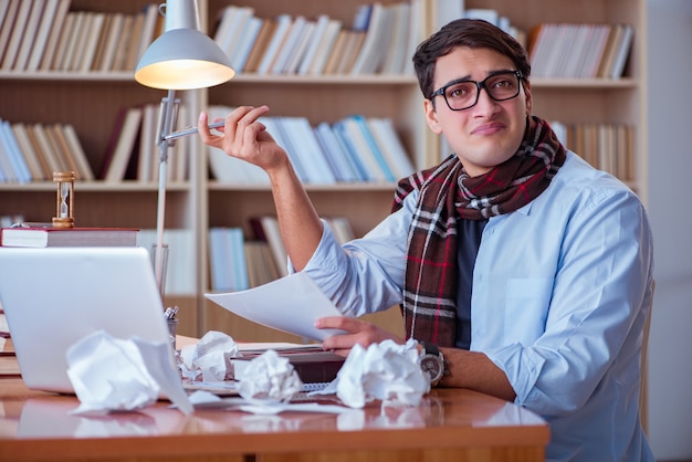 Young book writer writing in library