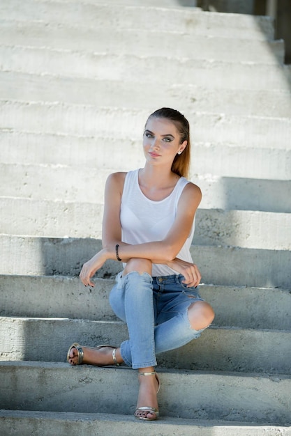 Photo young bosnian blonde woman with a ponytail posing near the stairs