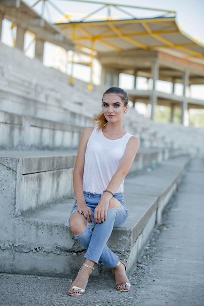 Young Bosnian blonde woman with a ponytail posing near the stairs