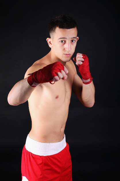 Young Boxer fighter over black   