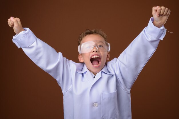 young boy as doctor on brown wall