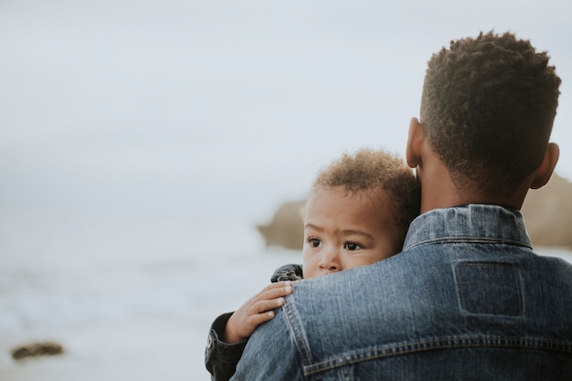 Photo young boy carried by his dad outdoors