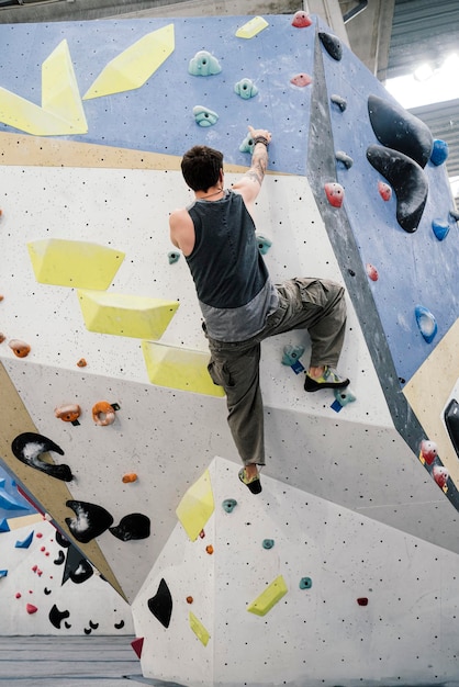 Young boy climbing a wall in an indoor climbing wall