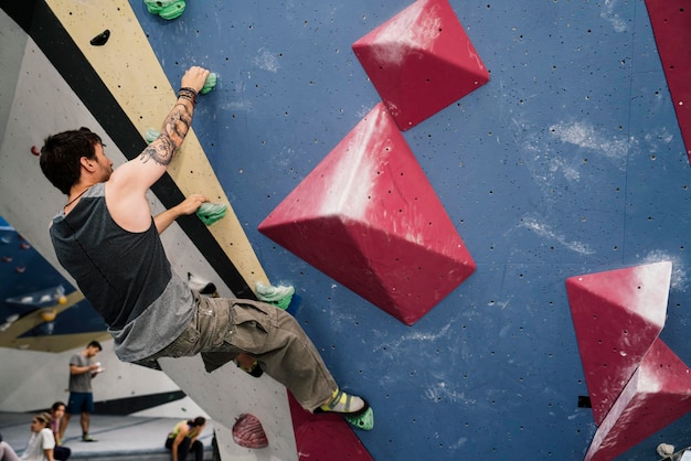 Young boy climbing a wall in an indoor climbing wall