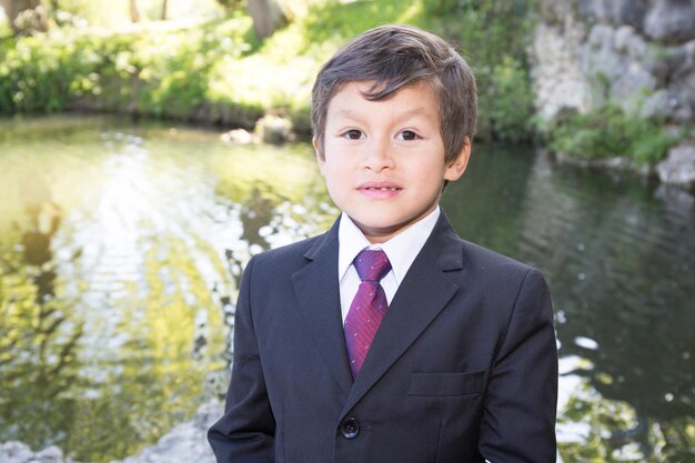 Young boy in costume and tie at the lake park