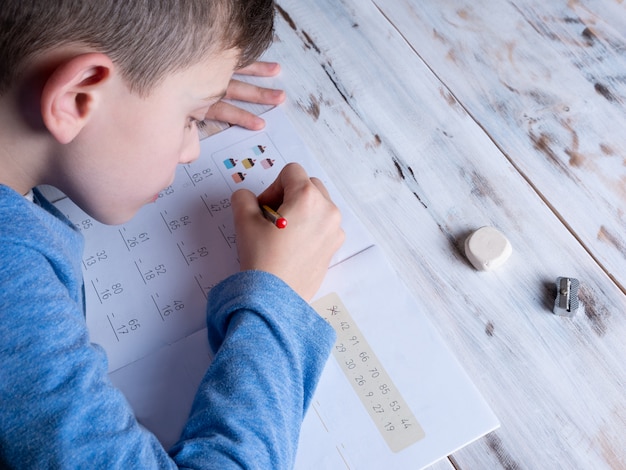 Photo young boy doing homework, home schooling concept