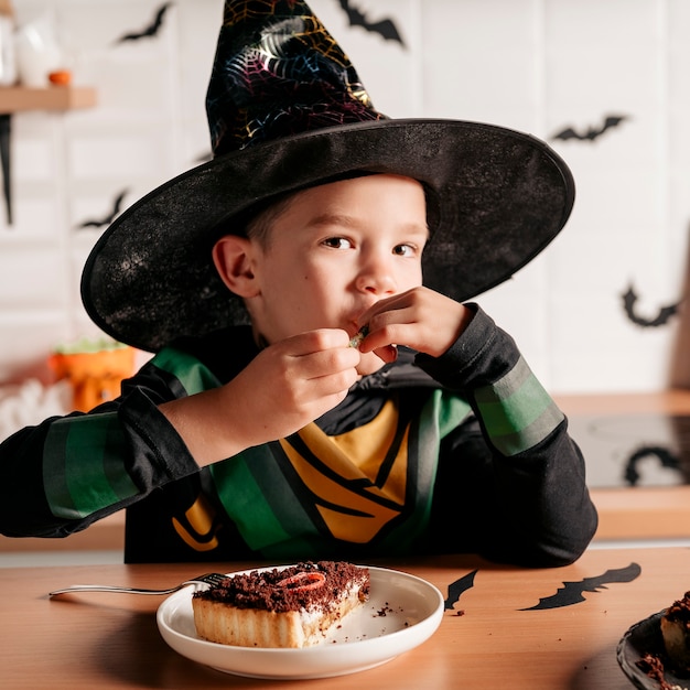 Young boy eating cake at Halloween party