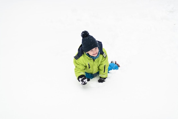 Photo young boy enjoying himself in the snow