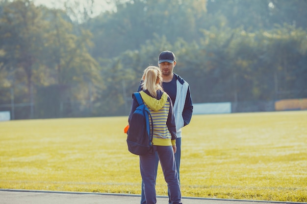 Young boy and girl before training talking in the stadium, preparing for workout